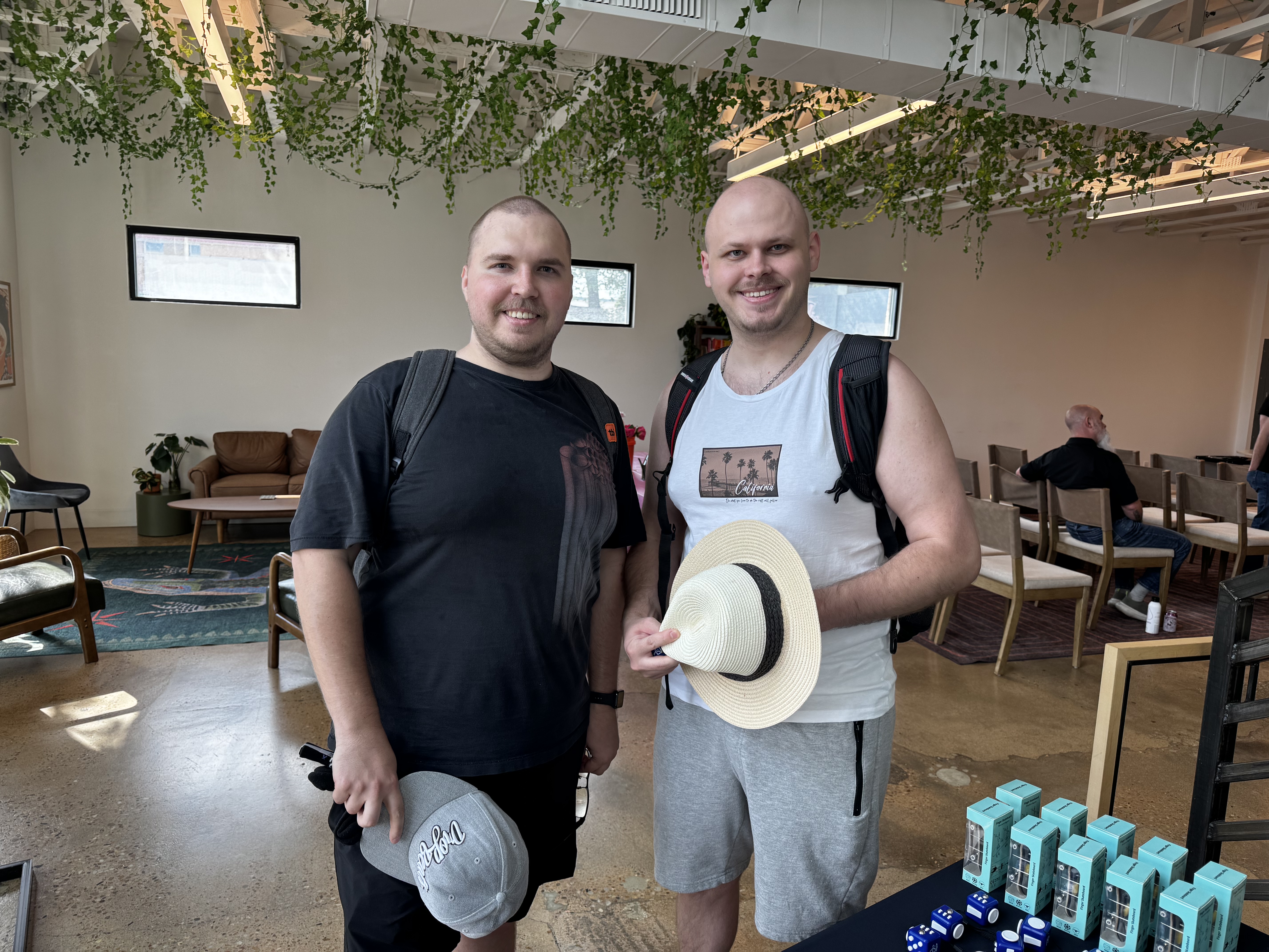 2 people smiling and wearing backpacks